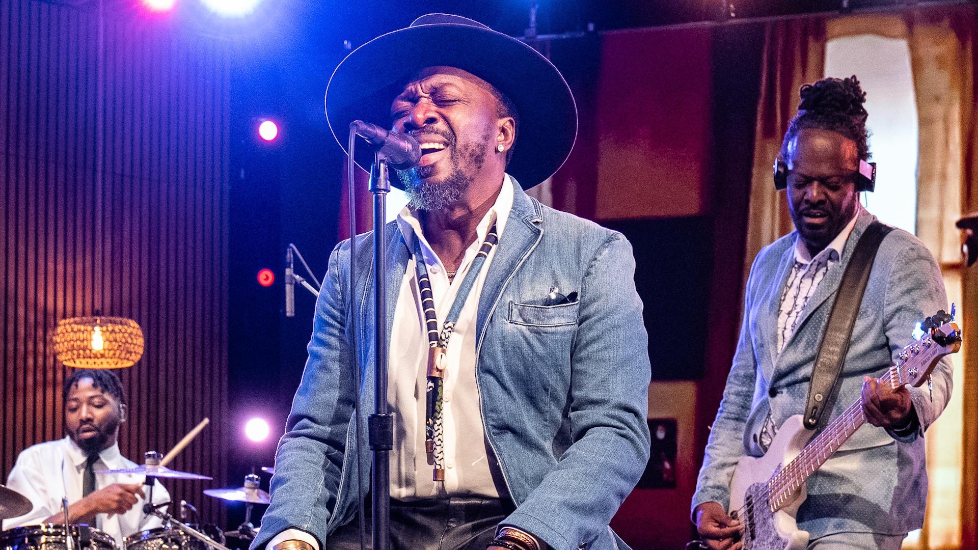 Singer Anthony Hamilton singing into a microphone on the set of Shaped by Sound.