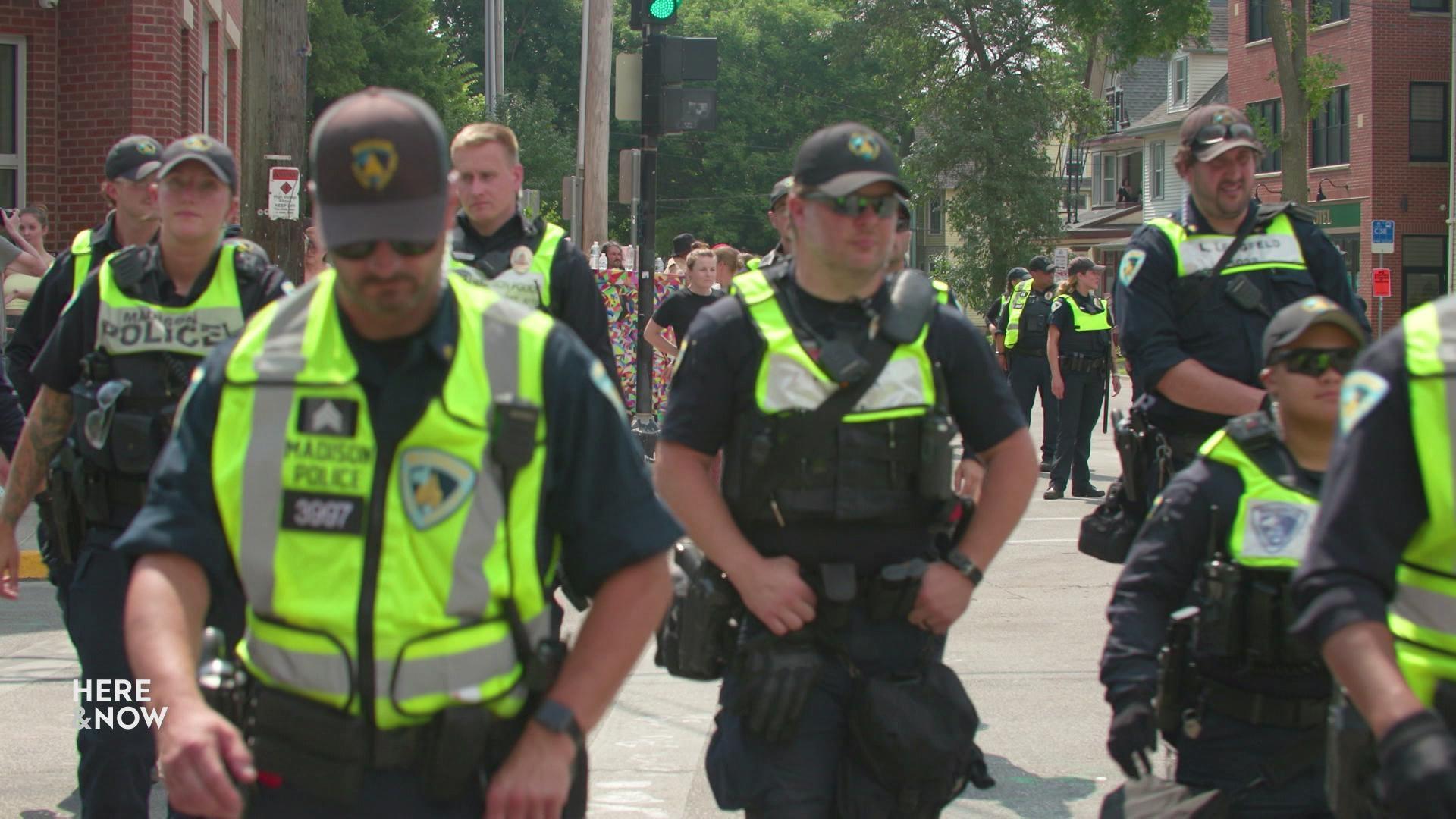 A still image shows a group of Madison police officers wearing high visibility vests walking toward the encampment at the intersection of Baldwin and Williamson Street. A still image shows a group of Madison police officers wearing high visibility vests walking toward the encampment at the intersection of Baldwin and Williamson Street.