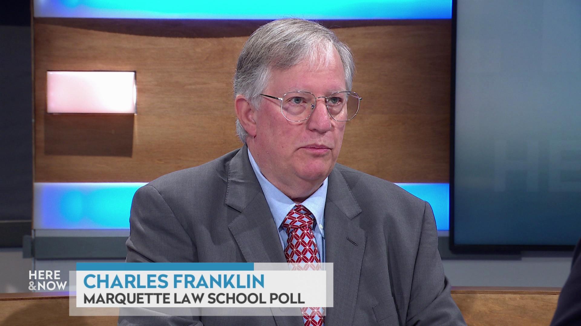 A still image shows Charles Franklin seated at the 'Here & Now' set featuring wood paneling, with a graphic at bottom reading 'Charles Franklin' and 'Marquette Law School Poll.'