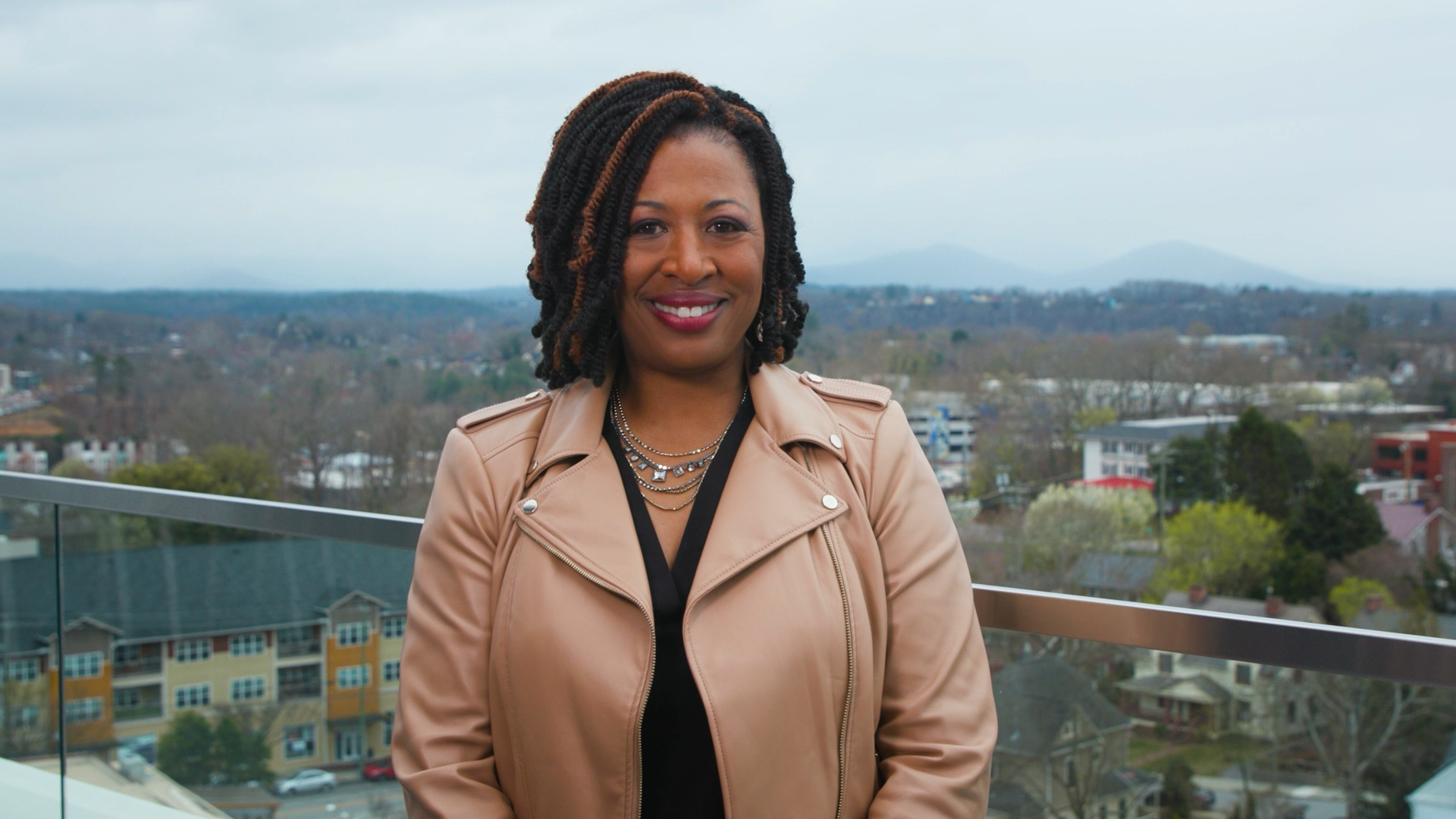 Host of NC Weekend Deborah Holt Noel with NC mountains behind her.
